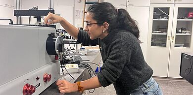 Person betätigt eine Maschine im Labor