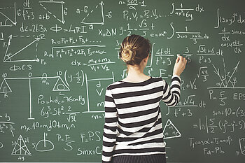 Formelmeisterin © iStock.com - Copyright seb ra Studierende schreibt eine Menge Formeln an die Tafel.